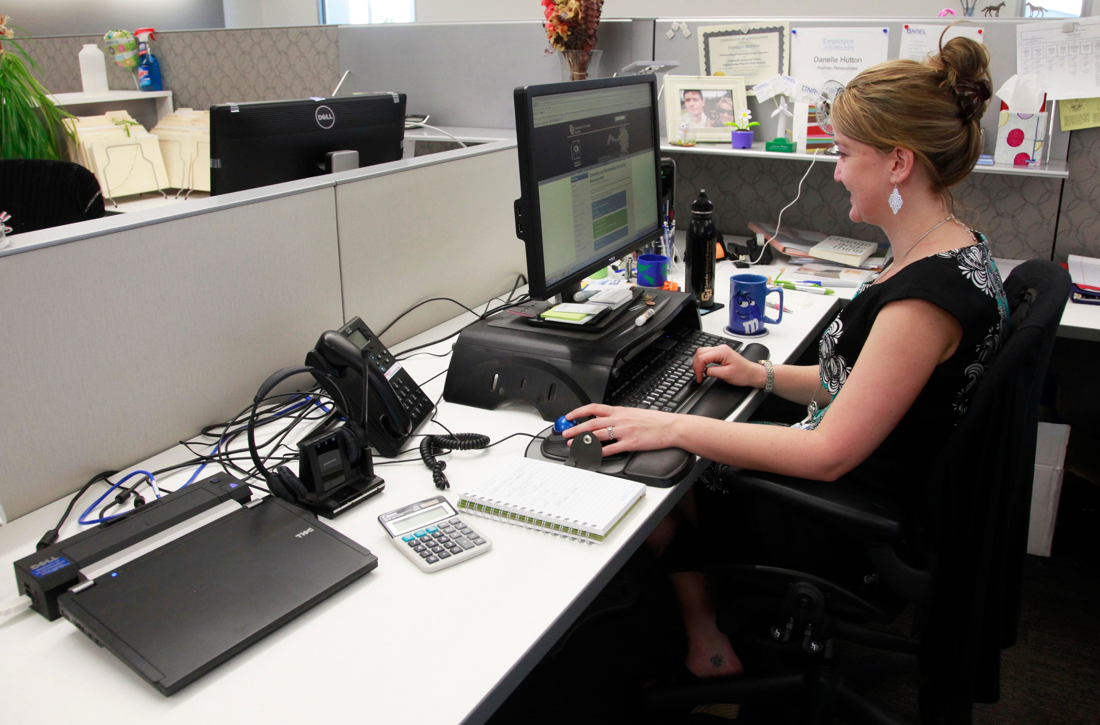 Danelle Hutton works on her laptop computer (left) in her open cubicle at the US National Renewable Energy Laboratory Research Support Facility (RFS) in Golden.