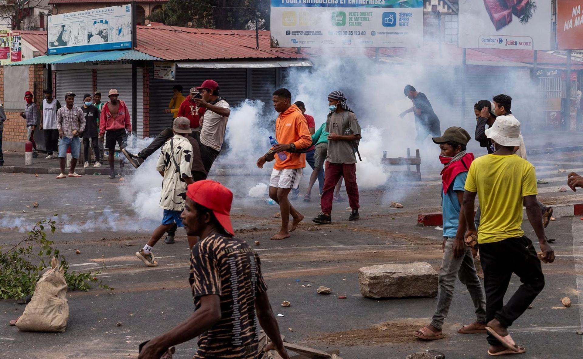 A protester kicks a tear gas canister lobbed by Malagasy riot police officers in Antananarivo, Madagascar. 