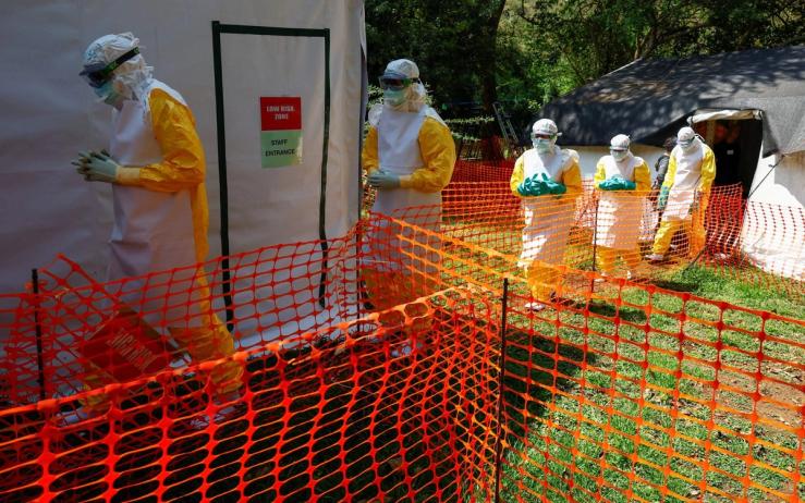 Health workers wearing Personal Protective Equipment walk in a formation during a training by Medecins Sans Frontieres in DR Congo.