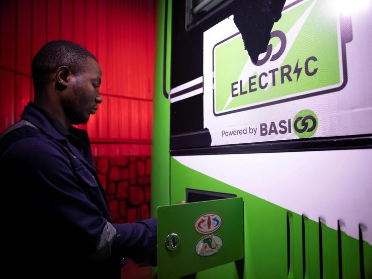 A worker charges an electric bus at a charging station in Kigali, Rwanda.
