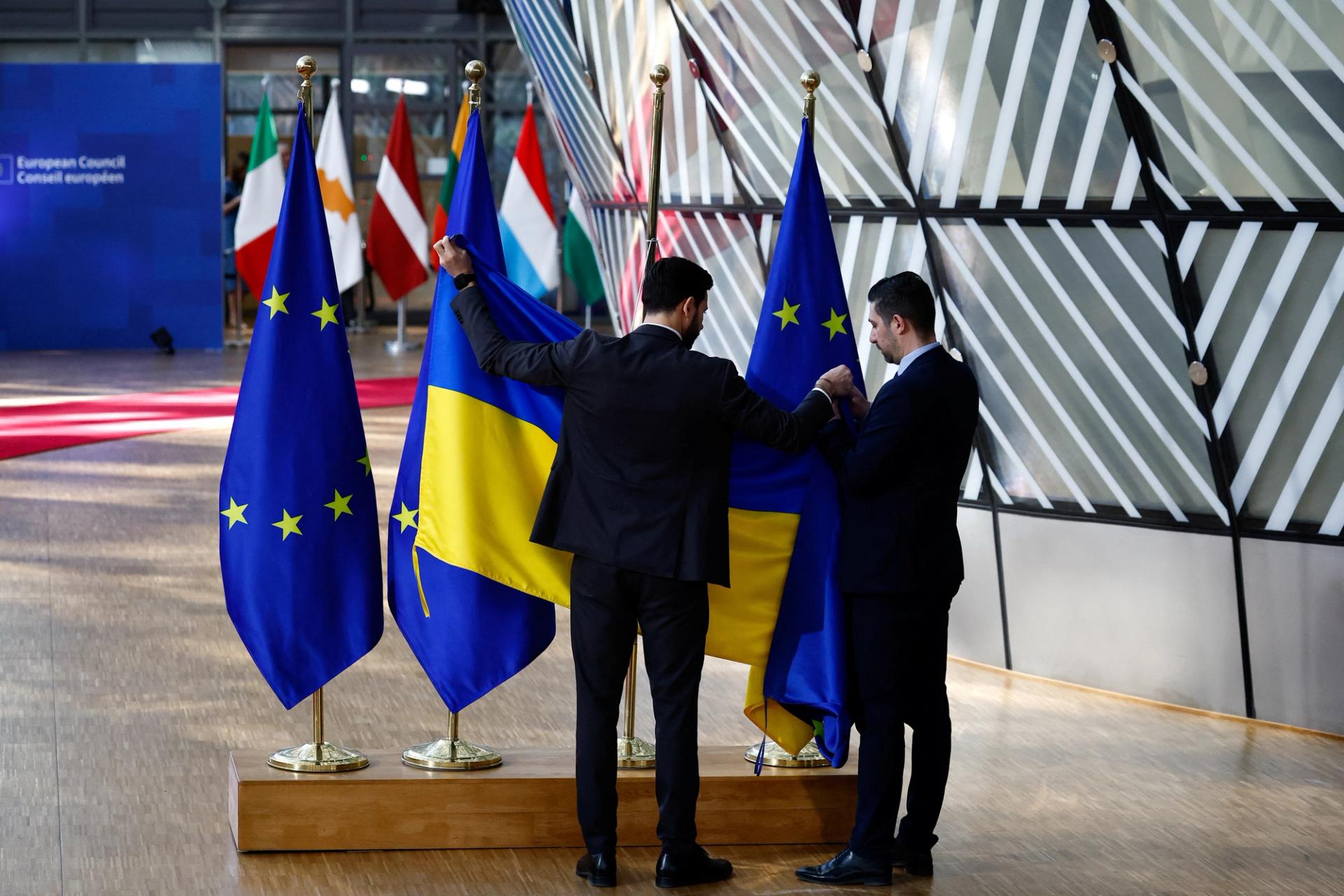 Ushers replace an EU flag with a Ukrainian flag on the day of the European Unit summit in Brussels. 