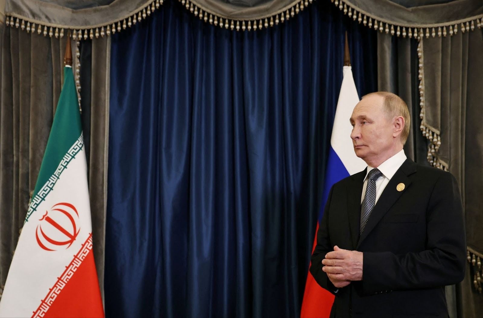 Putin next to an Iranian flag. 