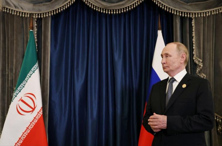 Putin next to an Iranian flag.