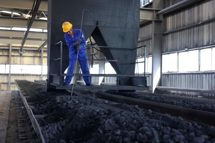A worker is loading materials into a calcination furnace at the production workshop of Zhonghai Graphite Co.