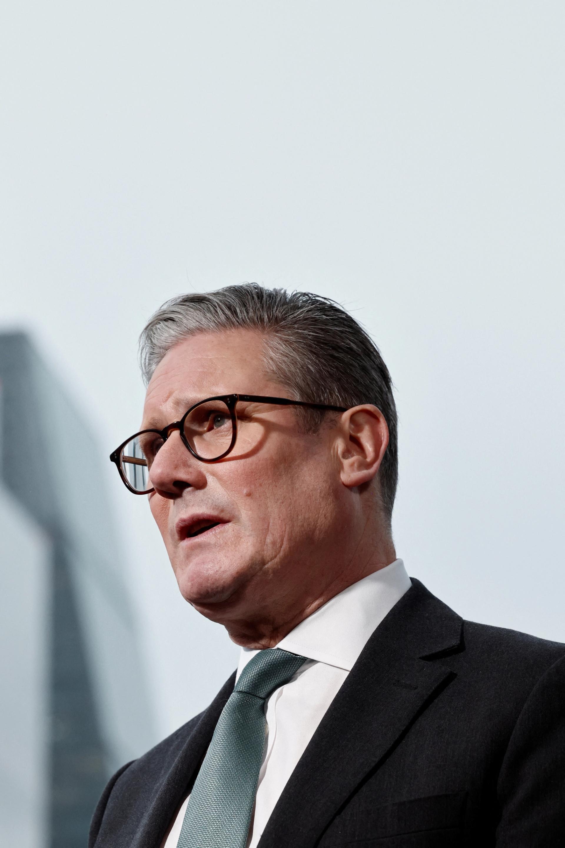 Keir Starmer, wearing a dark suit and tie, speaks at a meeting in London