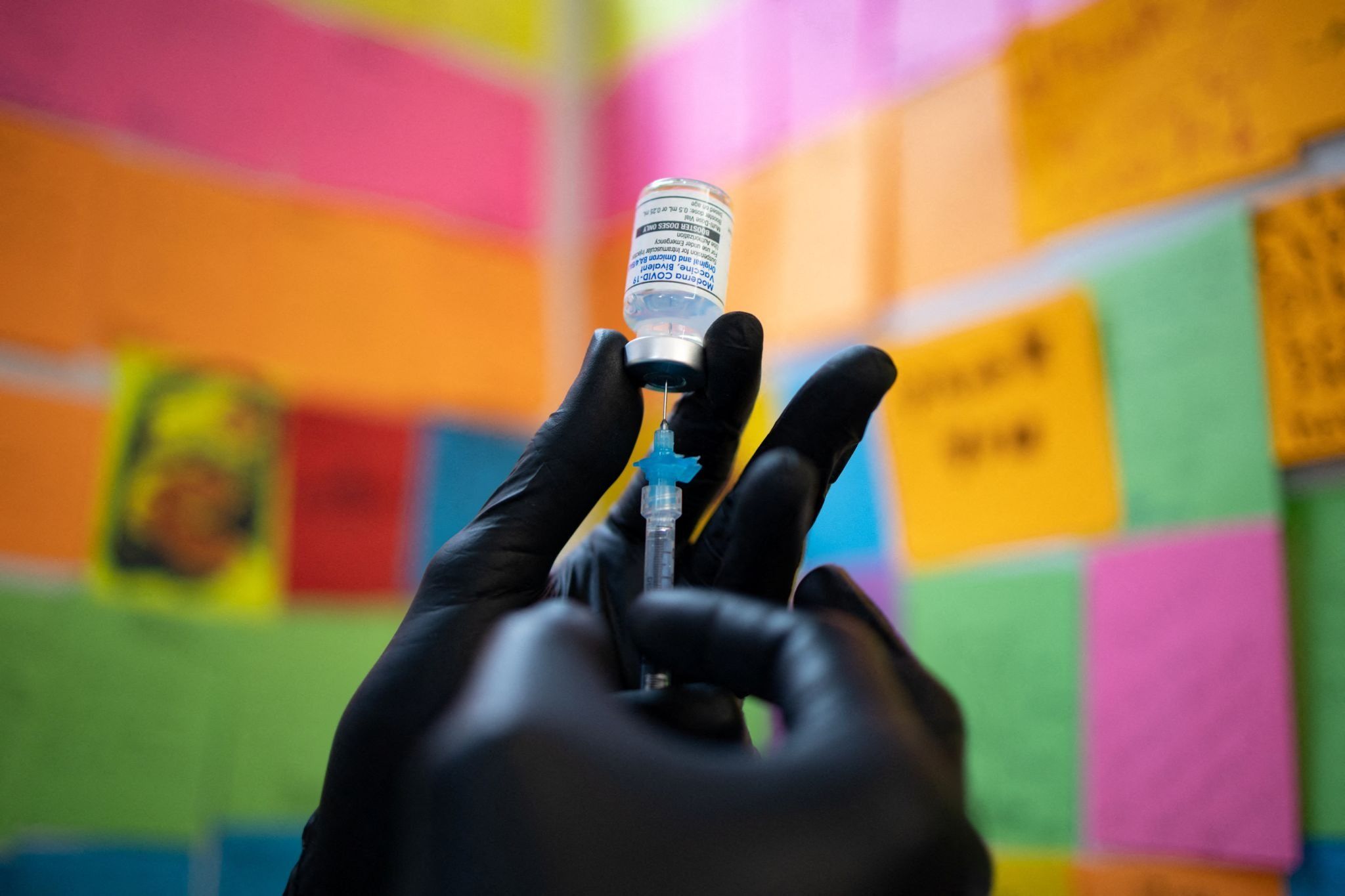 Gloved hands drawing a shot of Moderna vaccine