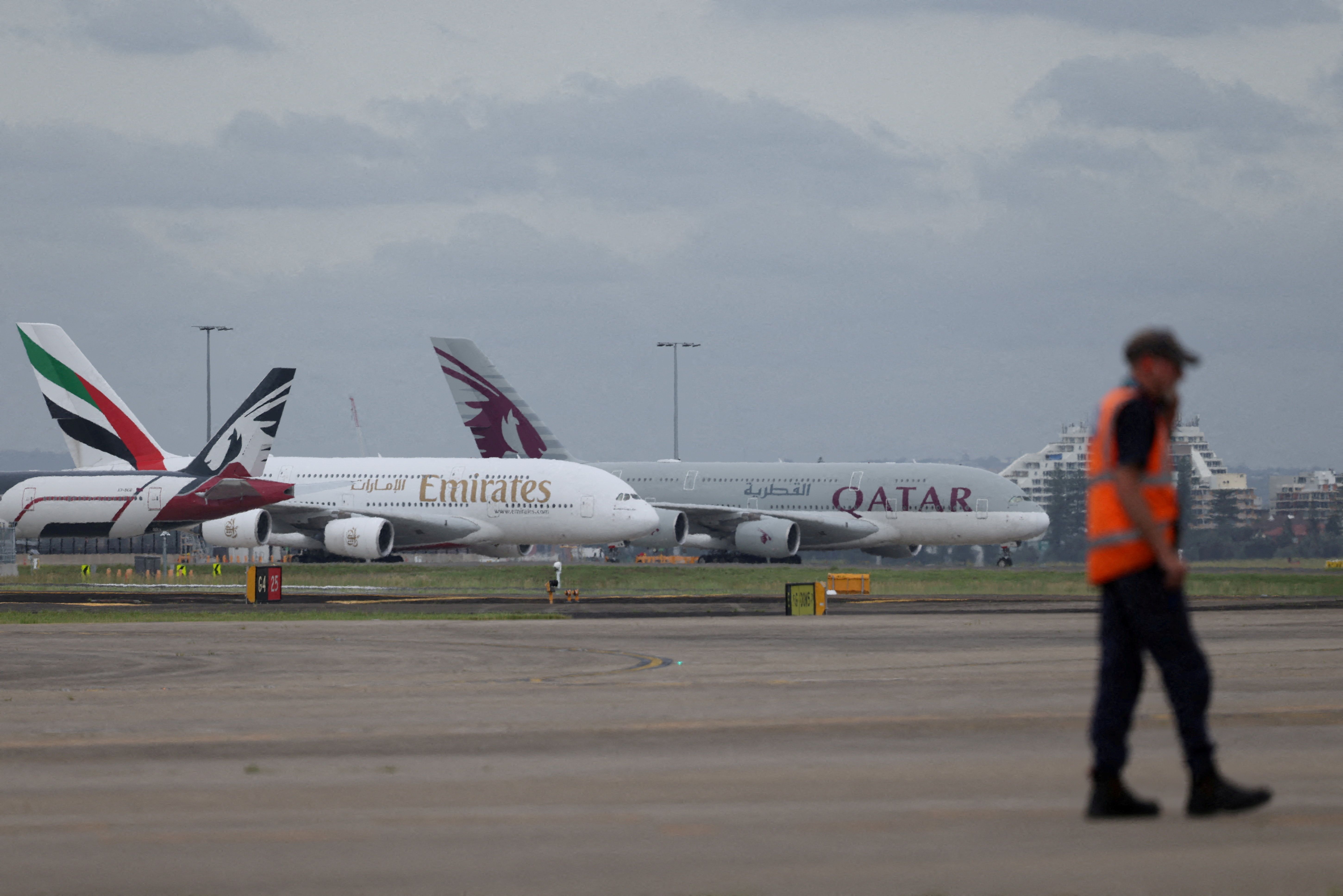Emirates and Qatar Airways planes sit on the tarmac at Sydney Kingsford Smith Airport in Sydney, Australia.