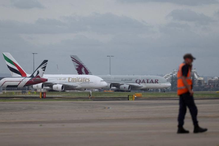 Emirates and Qatar Airways planes sit on the tarmac at Sydney Kingsford Smith Airport in Sydney, Australia.