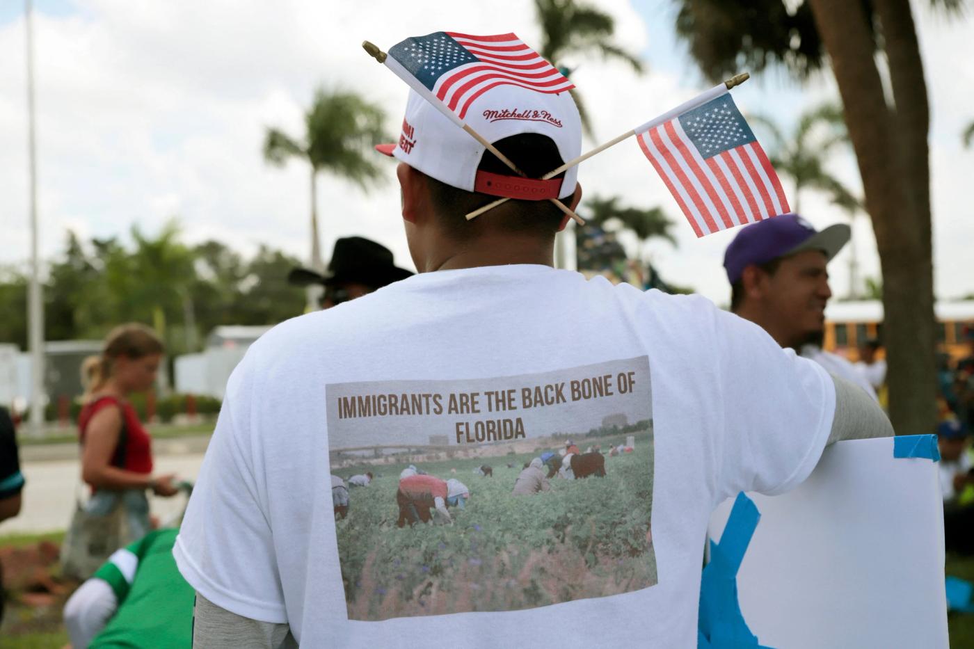 A man wears a shirt showing support for immigrants during a march against a new immigration law along Palm Beach Boulevard in Fort Myers, Florida, on June 28, 2023. 