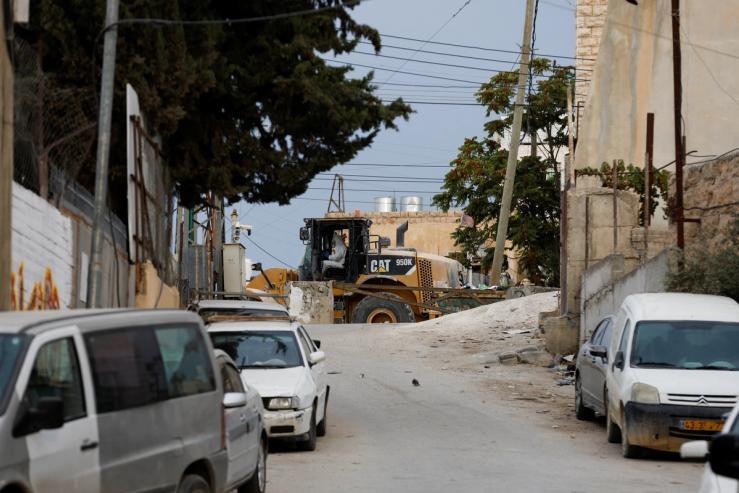 An Israeli security member drives a bulldozer used in an attack carried out by a Palestinian, who was shot and killed by Israeli troops, near the scene in Hebron in the Israeli-occupied West Bank October 9, 2023. REUTERS/Mussa Qawasma