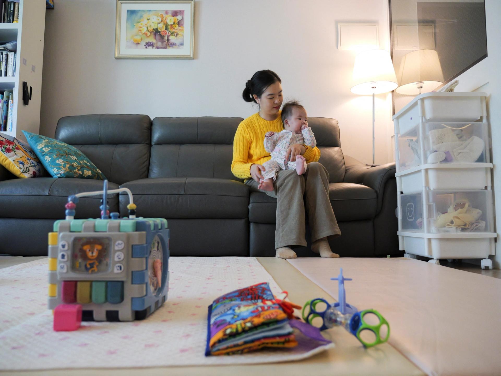 Nam Hyun-jin takes care of her baby at her home in Seoul, South Korea.