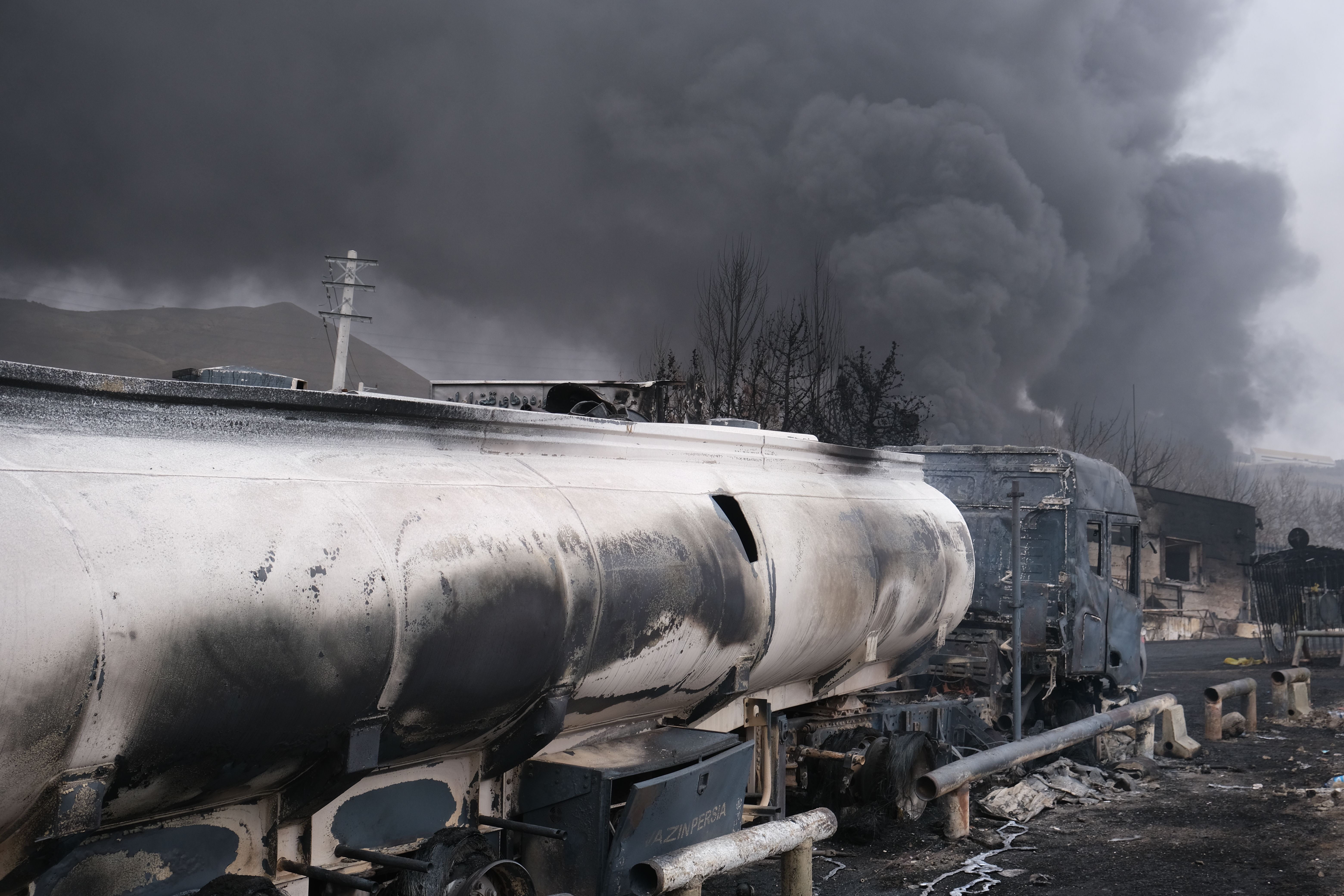 Plumes of smoke rise over the oil depot tanks hit by joint Israel-US strike in Tehran.