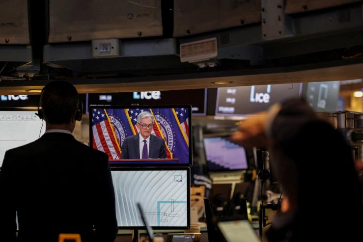 Traders work, as a screen broadcasts a press conference by U.S. Federal Reserve Chair Jerome Powell following the Fed rate announcement, on the floor of the NYSE in New York, U.S., July 30, 2025.