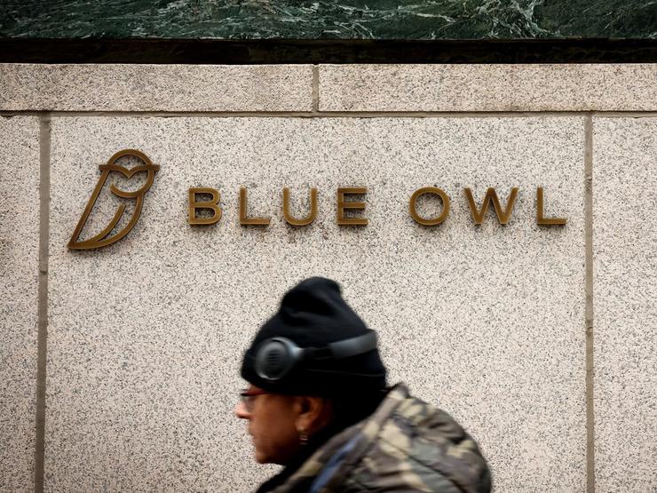 A logo for Blue Owl Capital is displayed on a midtown Manhattan office building.