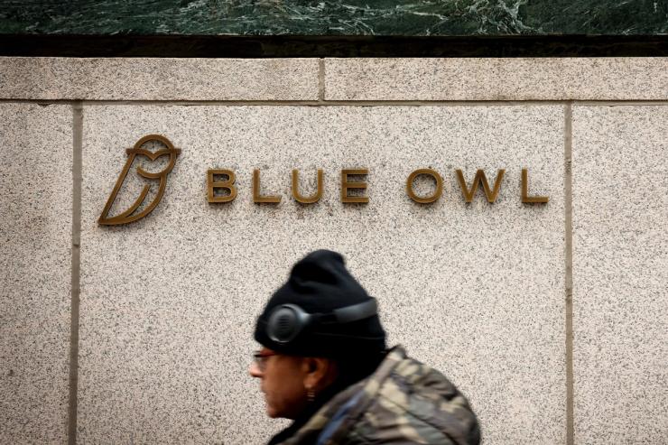 A logo for Blue Owl Capital is displayed on a midtown Manhattan office building.