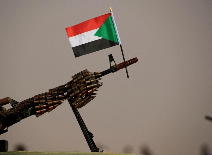 A Sudanese national flag is attached to a machine gun.