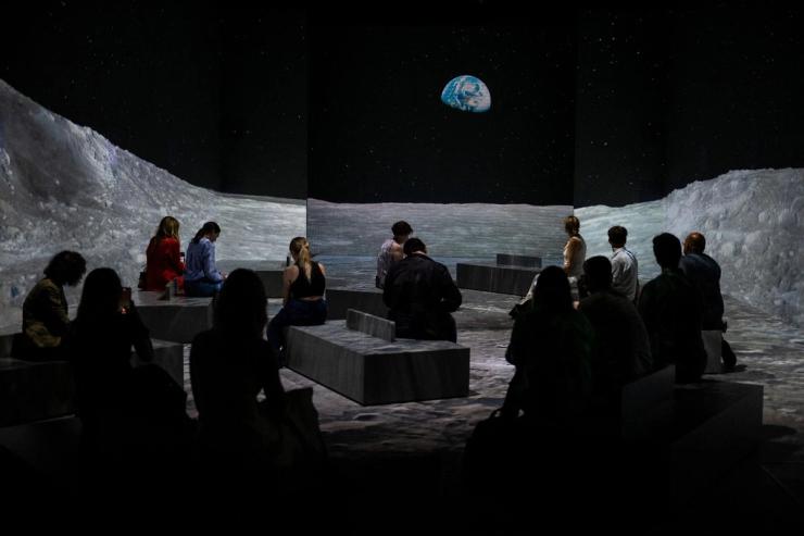 Members of the media watch a press preview of the immersive experience ‘Our Story with David Attenborough’ at the Natural History Museum, in London.