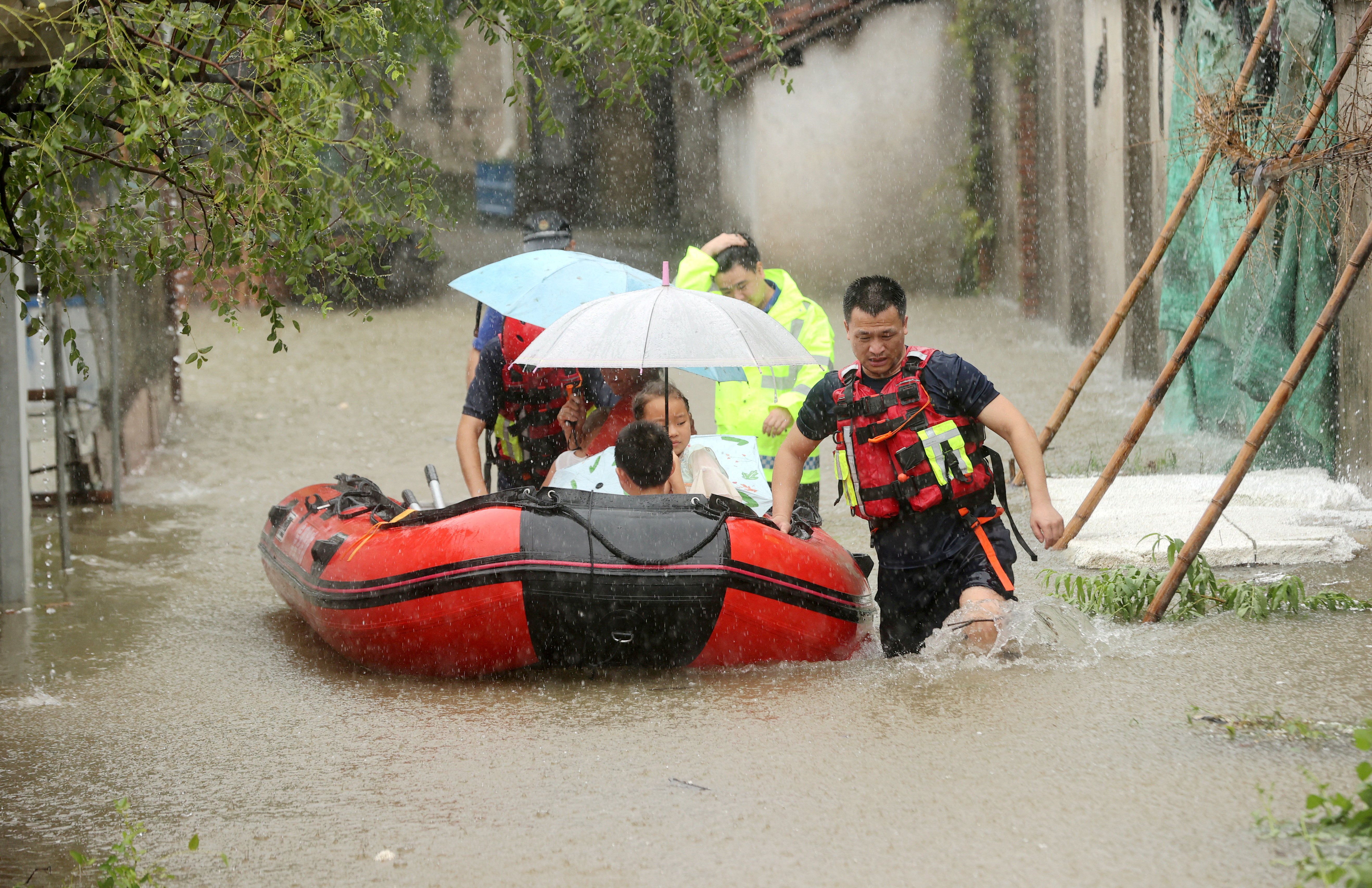 Rescue workers evacuate stranded villagers by lifeboat at a flooded village.