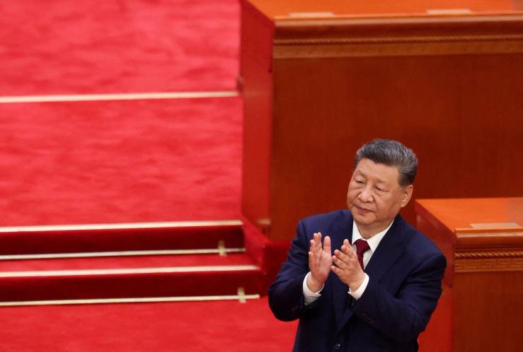 Chinese leader Xi Jinping applauds during a ceremony.