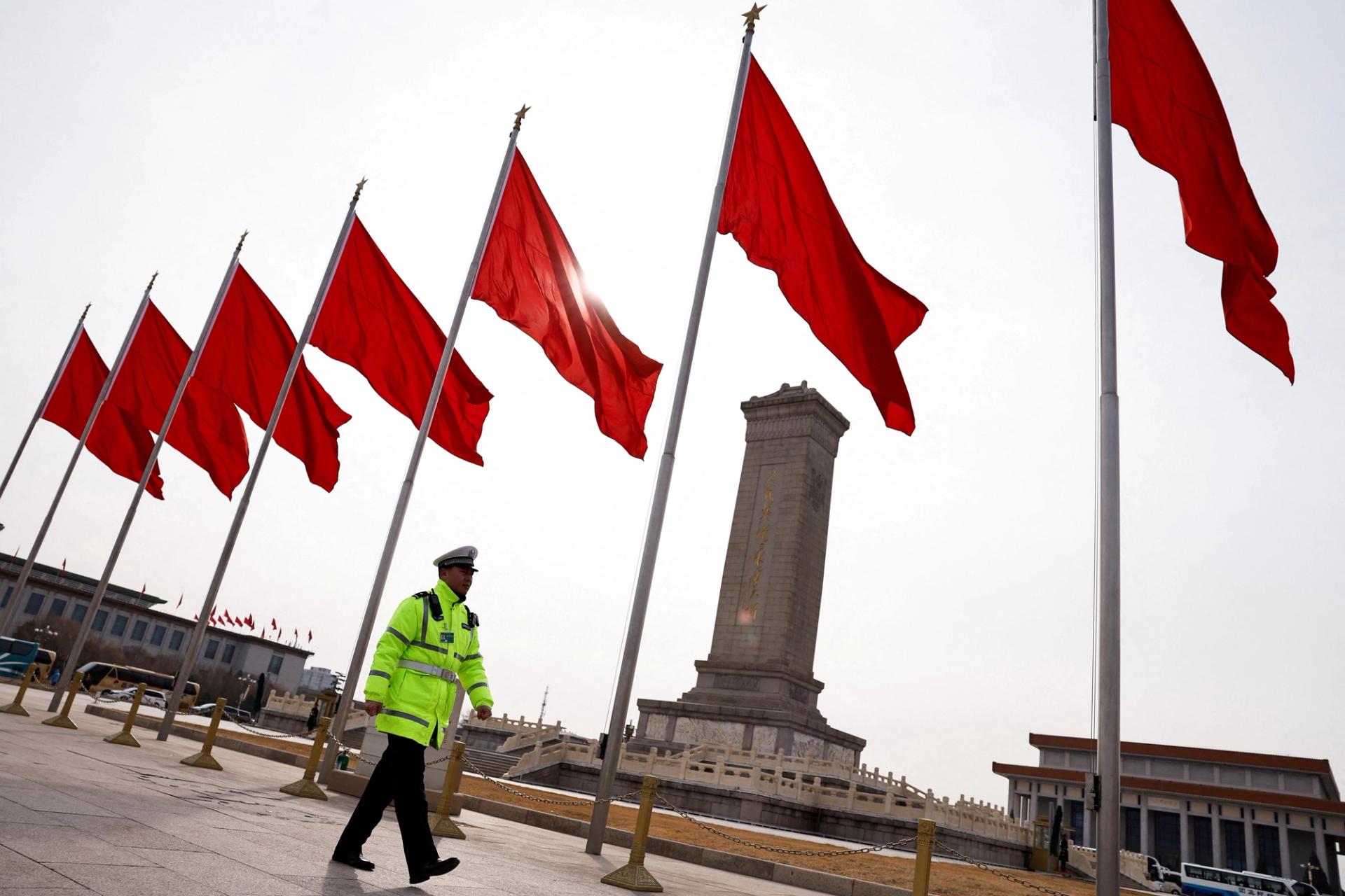 A police officer walks past red flags, at Tiananmen Square, in Beijing.