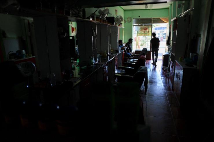 Workers at a barber shop take a break during a power outage in Cape Town.