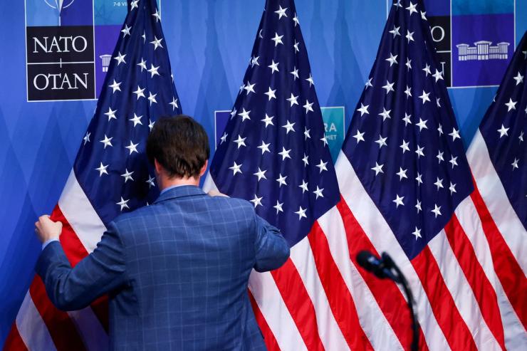 US flags in front of NATO banners.