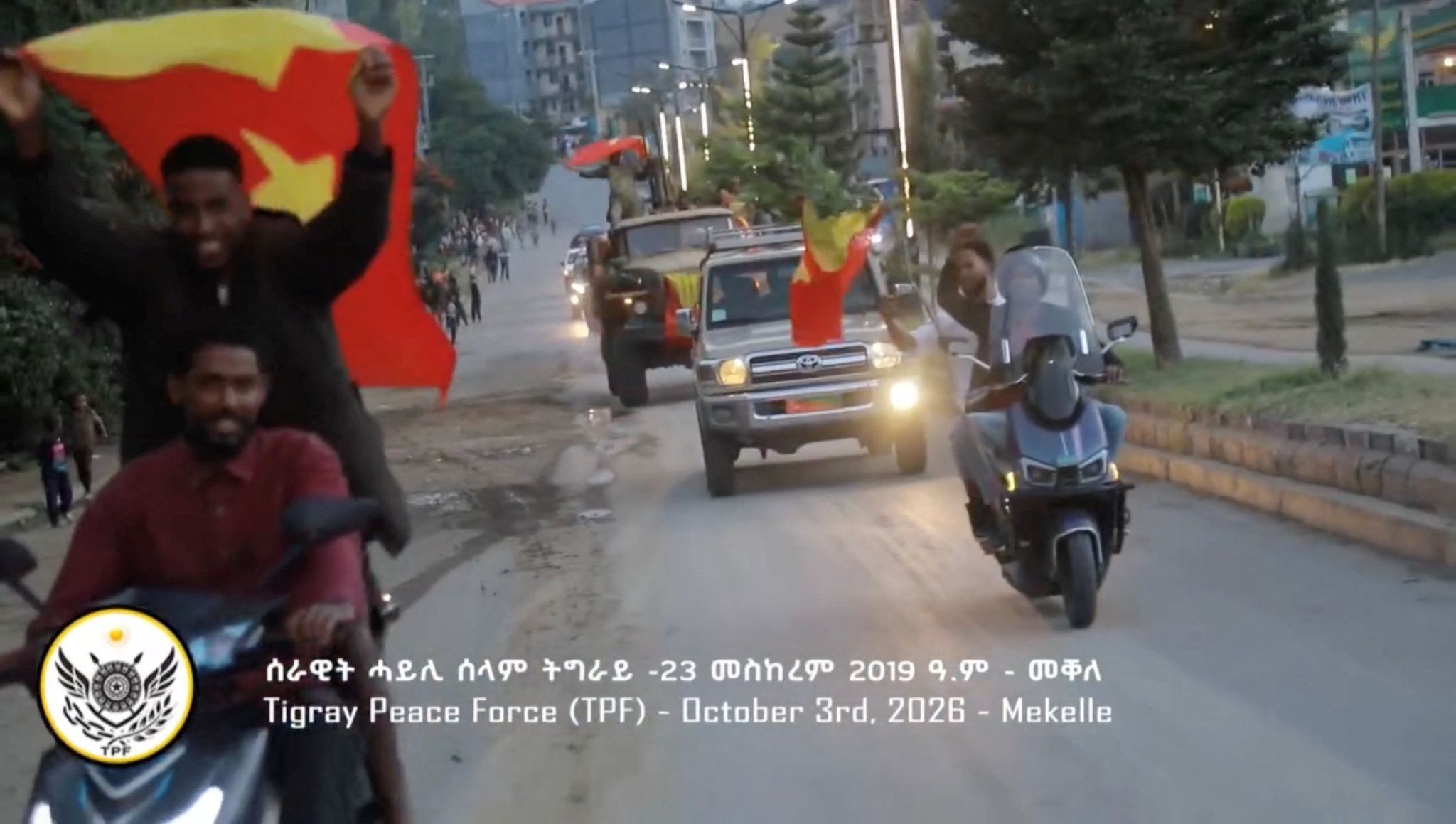 Men riding motorcycles wave flags of the Tigray region in Mekelle, Ethiopia