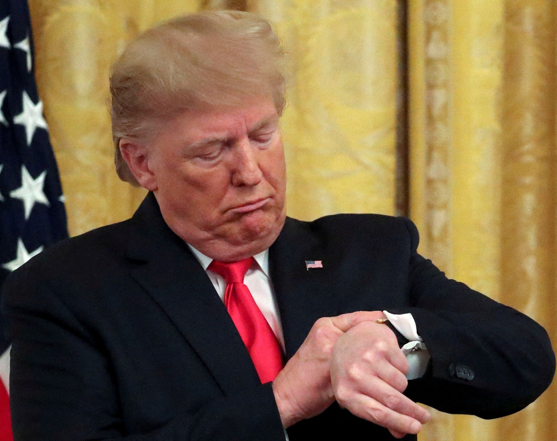 President Donald Trump checks his watch