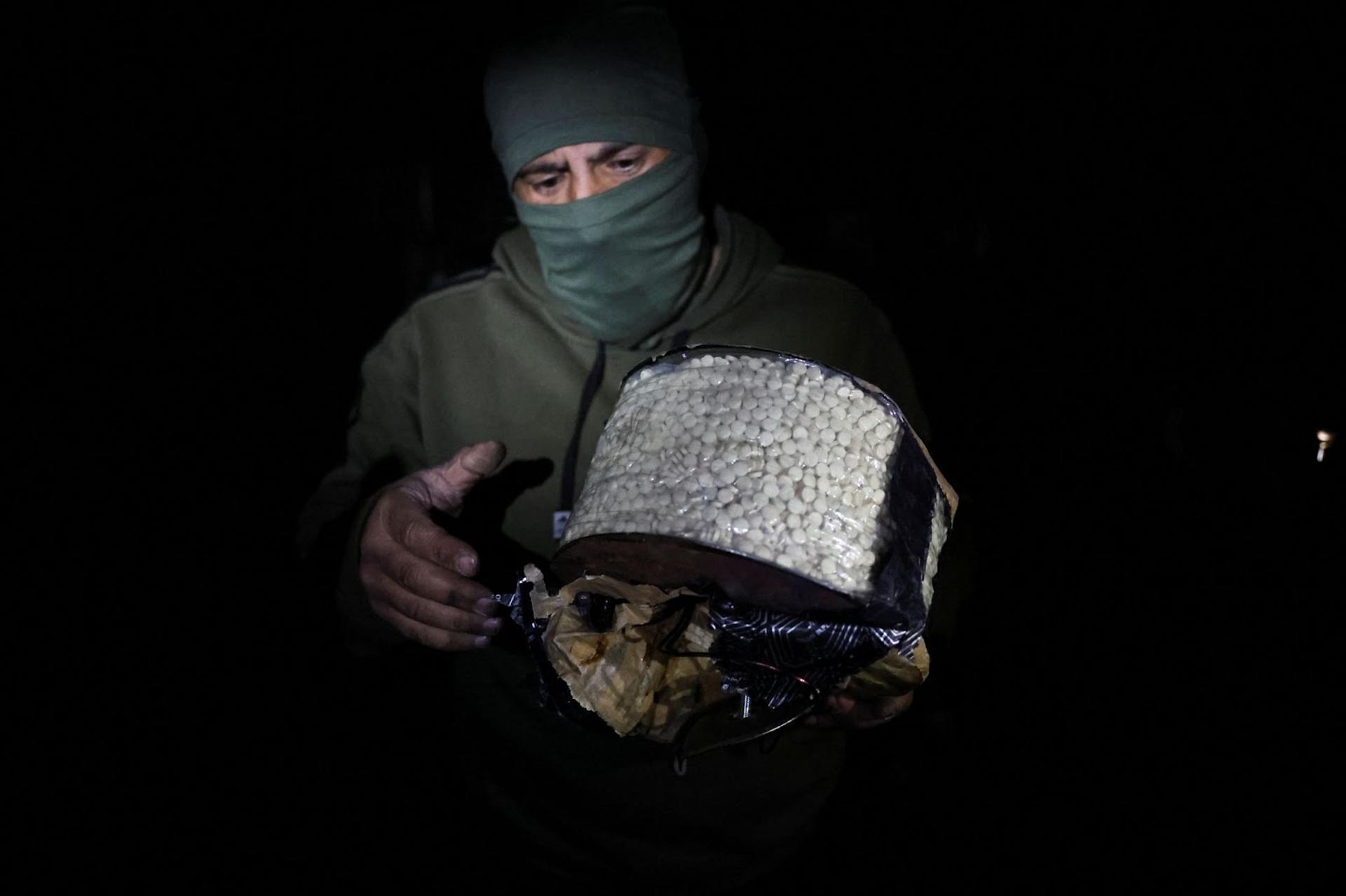 Fighter, loyal to Syria’s new ruling administration, holds a box containing according to them, captagon pills, on the outskirts of Damascus