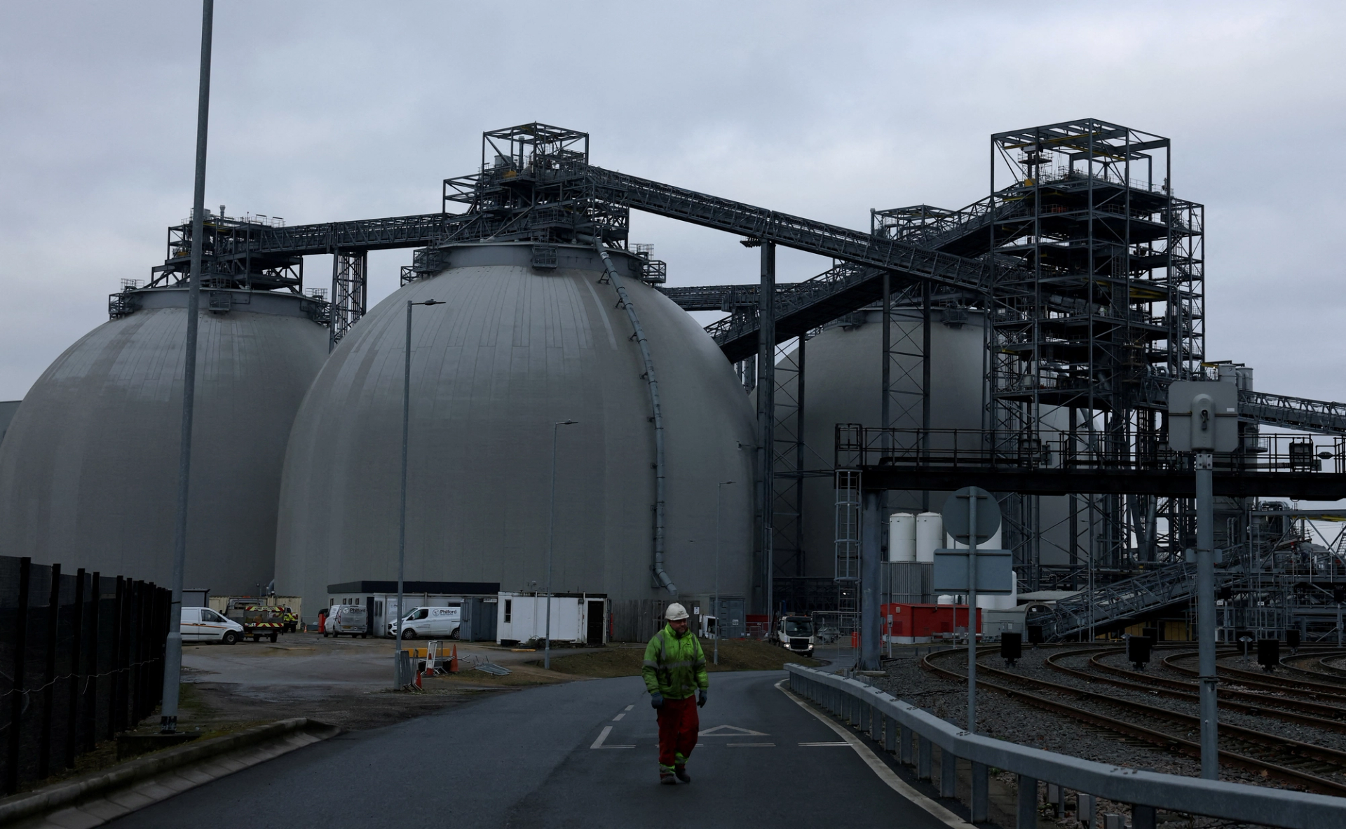 A worker walks in front of the biomass storage domes at the Drax Power Station near Selby, Britain, December 13, 2024.