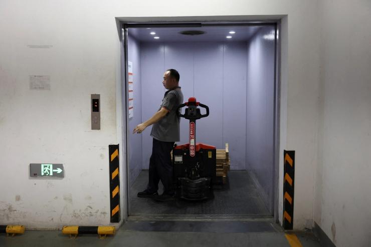 An employee presses an elevator button in a warehouse in Ganzhou.