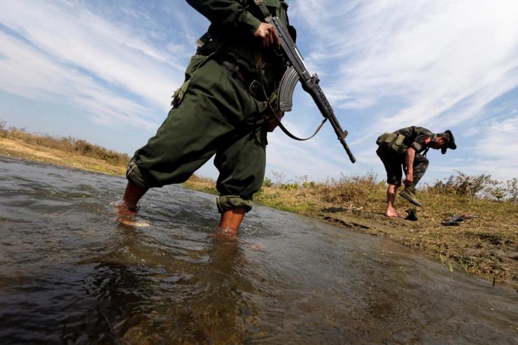 Rebels wade in a creek in Myanmar