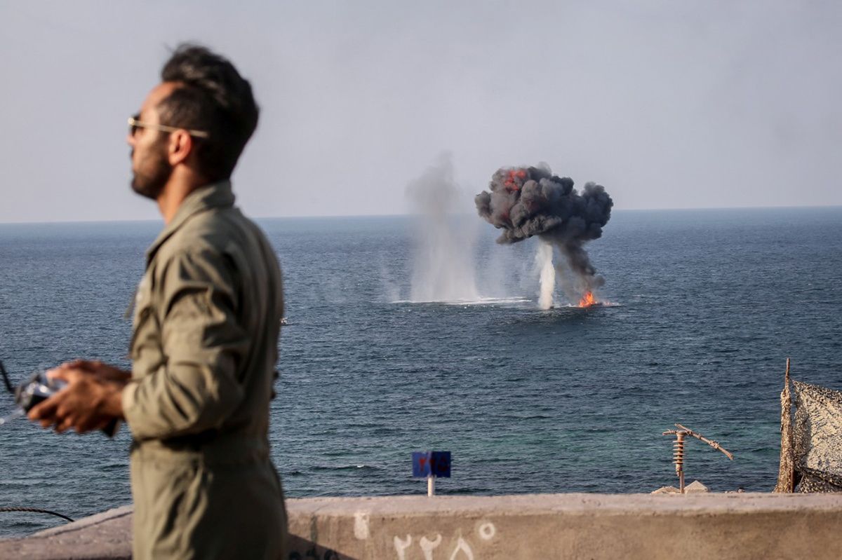  An explosion is seen behind a member of the Islamic Revolution Guards Corps during a joint military exercise called the ‘Great Prophet 17’ in the southwest of Iran, in this picture obtained on Dec. 22, 2021.