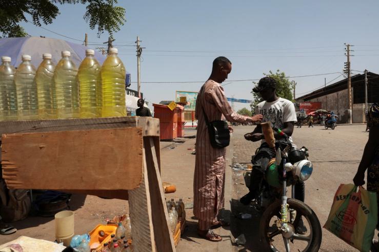 A street vendor sells petrol to a motorcyclist in Cameroon, March 22, 2026