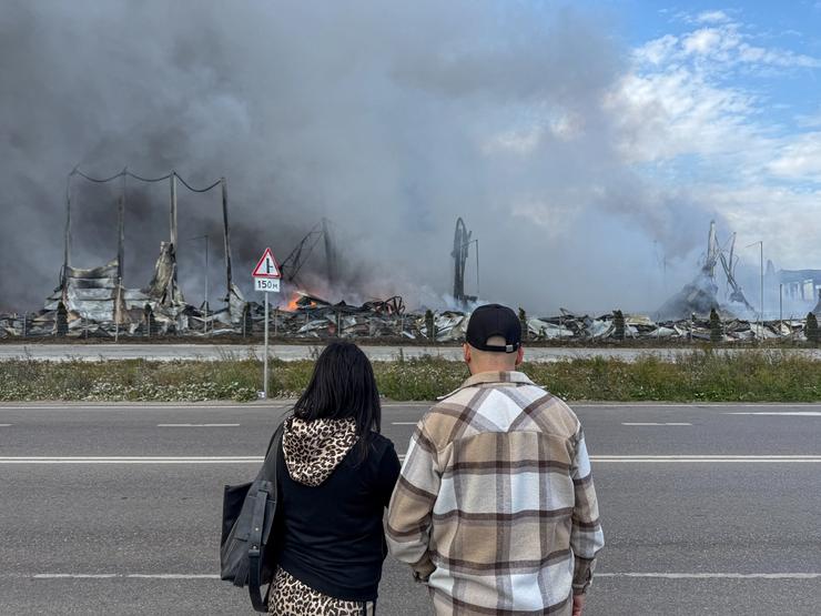 Onlookers look at the aftermath of a Ukrainian drone strike near Moscow