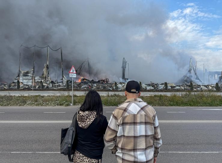 Onlookers look at the aftermath of a Ukrainian drone strike near Moscow