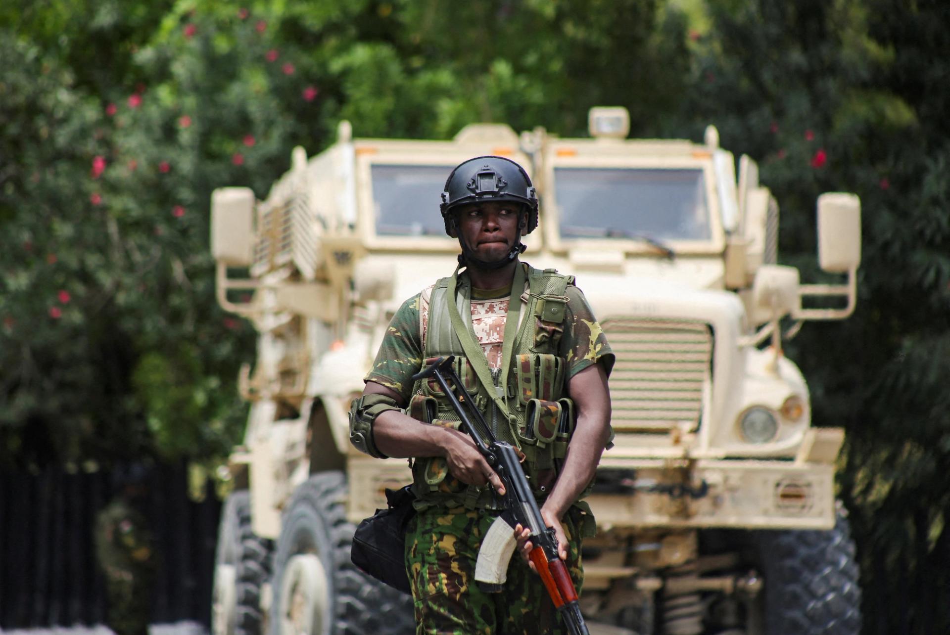 A Kenyan police officer walks in front of an armoured personnel carrier during a joint operation with Haitian police, in Port-au-Prince, Haiti