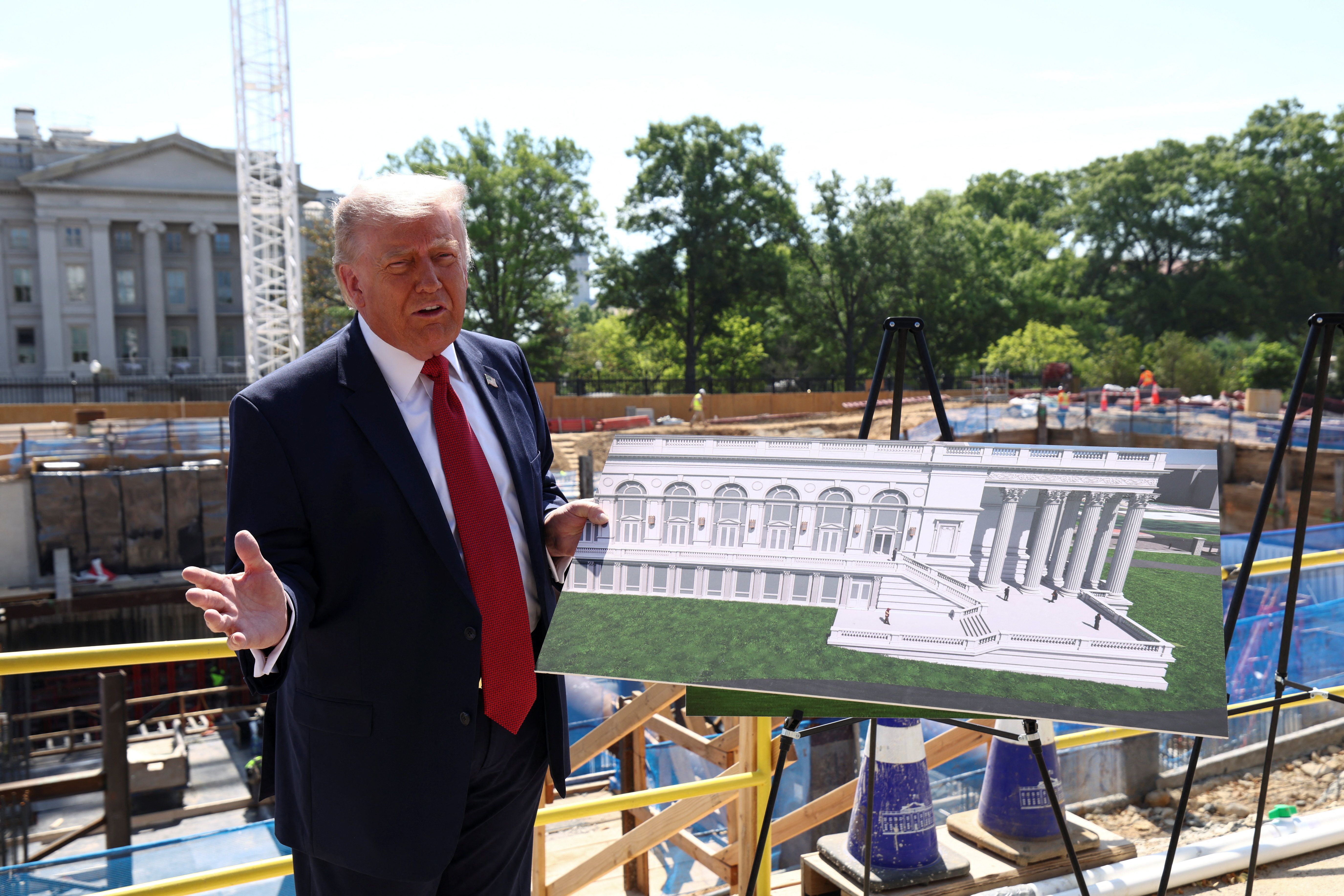 President Donald Trump shows images of the concept at the site of ongoing construction of the planned White House ballroom