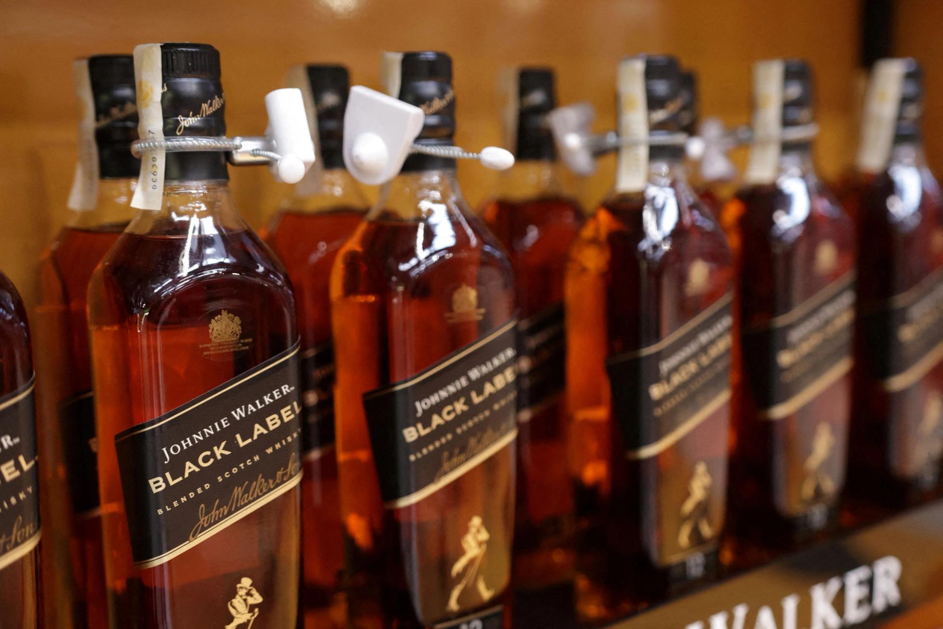 Johnnie Walker bottles are displayed on a shelf in a supermarket. 