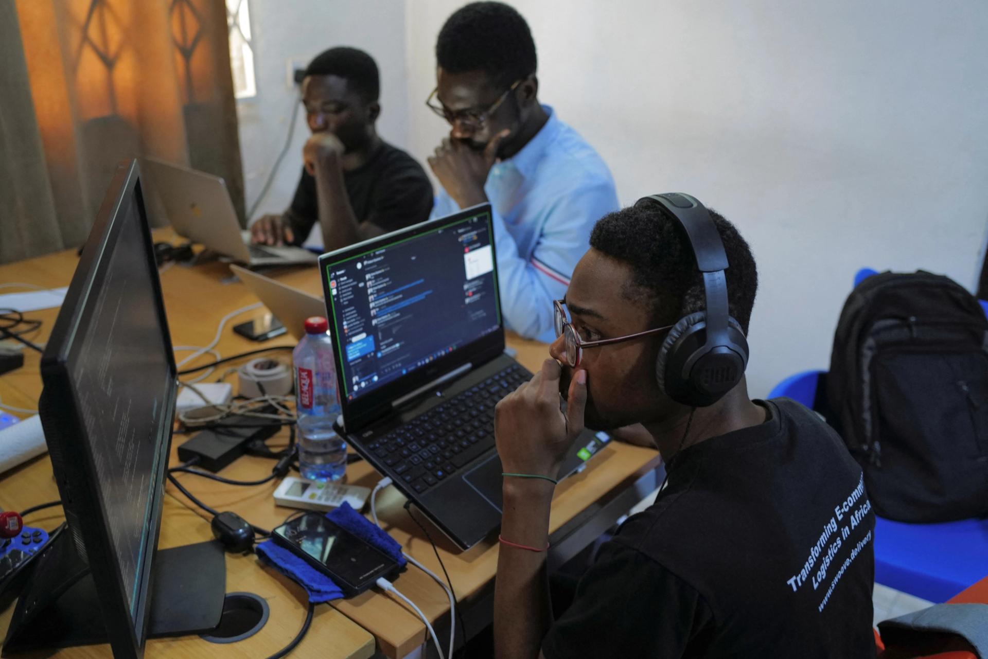 Three men using computers at an office in Ghana