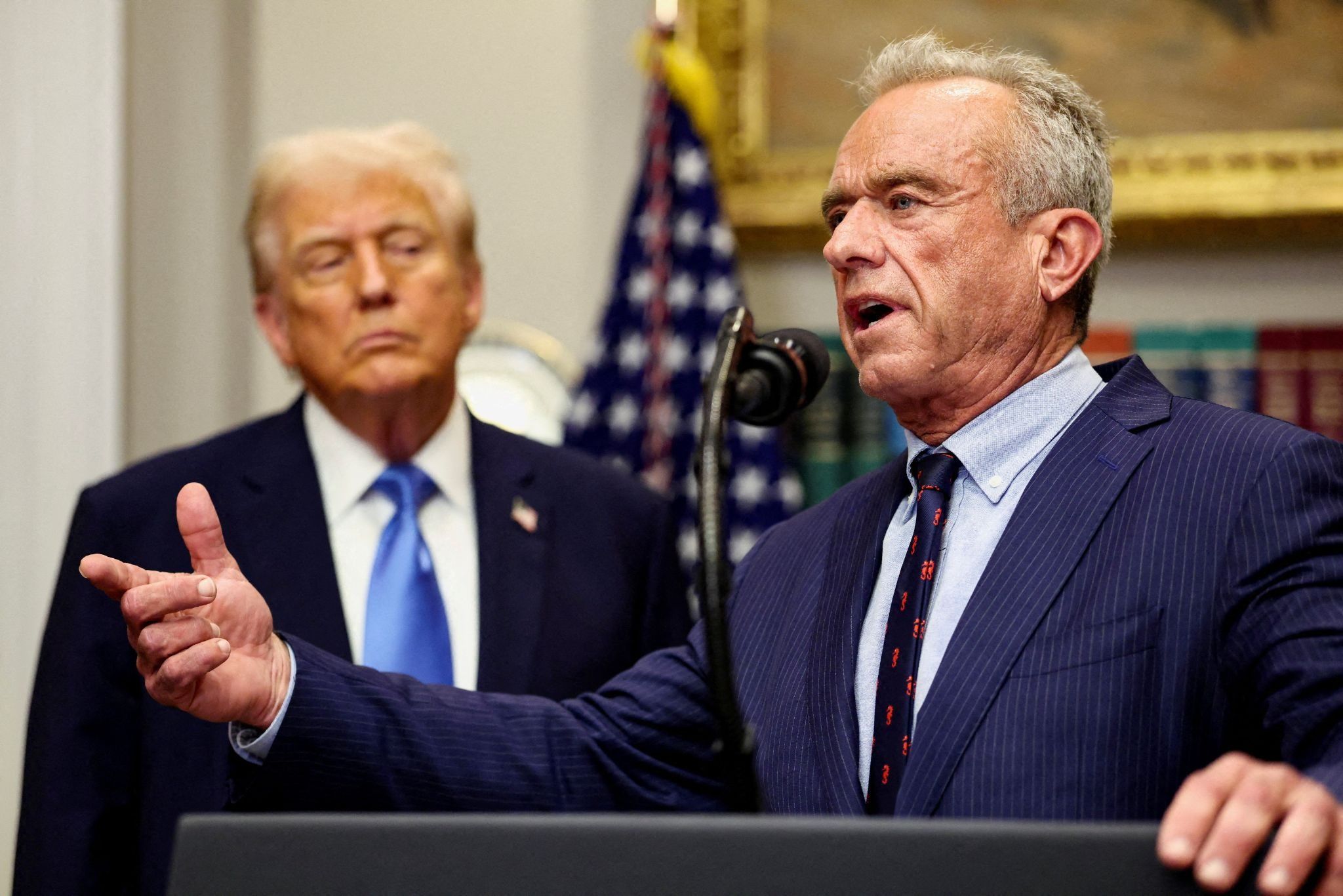 U.S. Secretary of Health and Human Services Robert F. Kennedy Jr. delivers remarks while U.S. President Donald Trump listens during a press conference