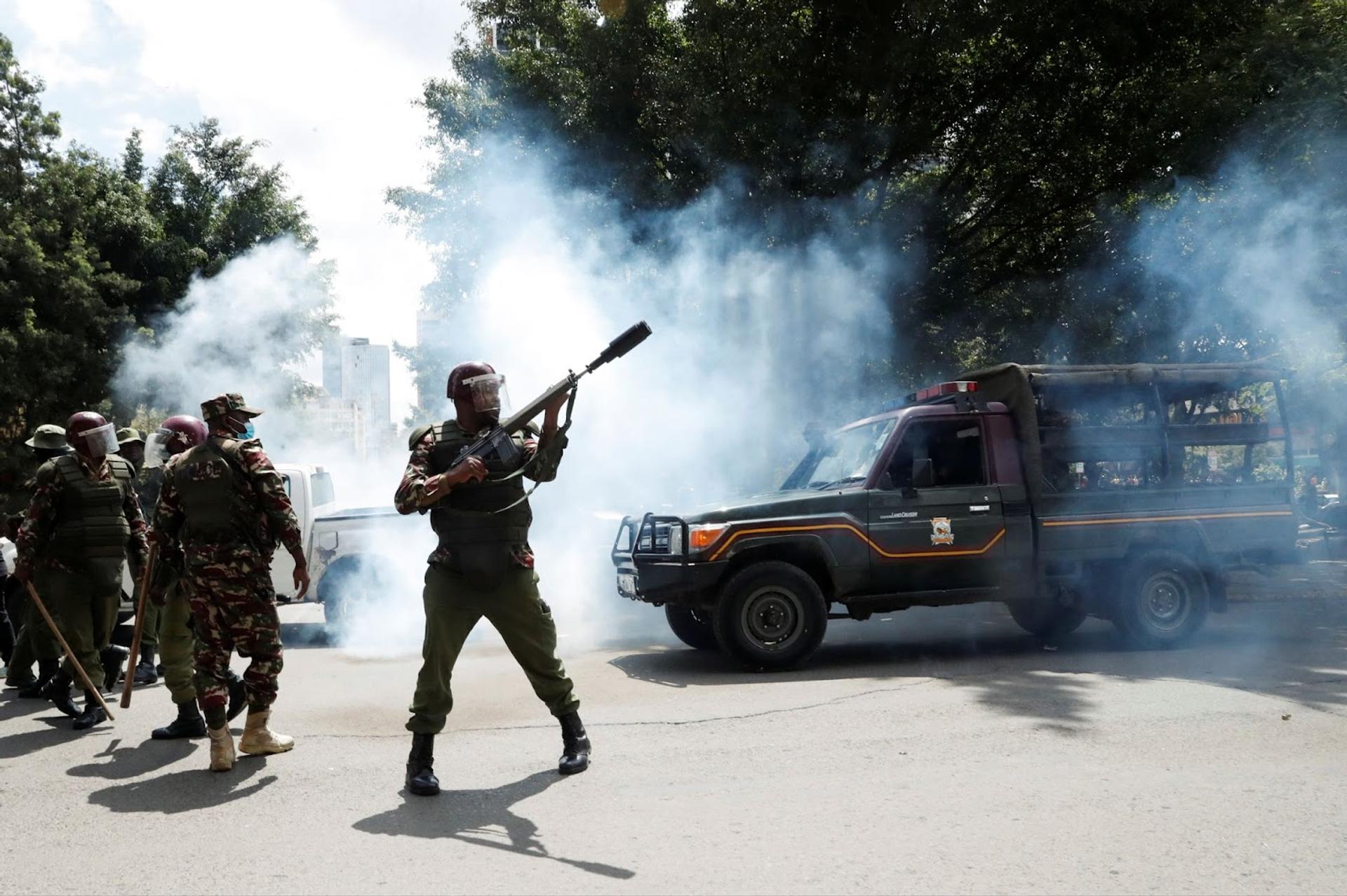 Security officials wield weapons in patrolling anti-government protests
