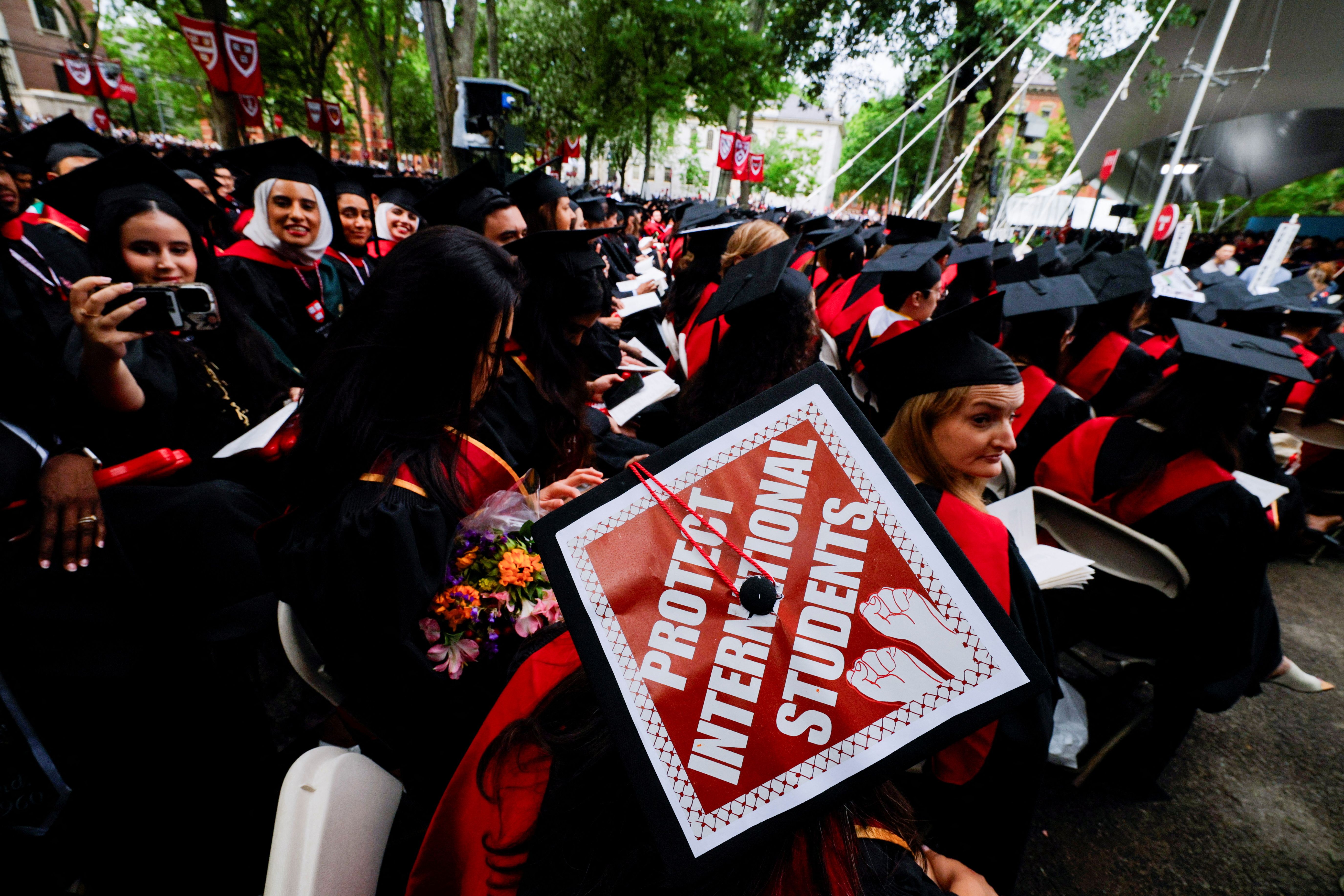 A graduating student wears their hat, decorated with a statement of support for international students, during the 374th Commencement exercises at Harvard University in Cambridge.
