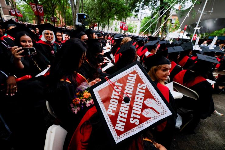 A graduating student wears their hat, decorated with a statement of support for international students, during the 374th Commencement exercises at Harvard University in Cambridge.