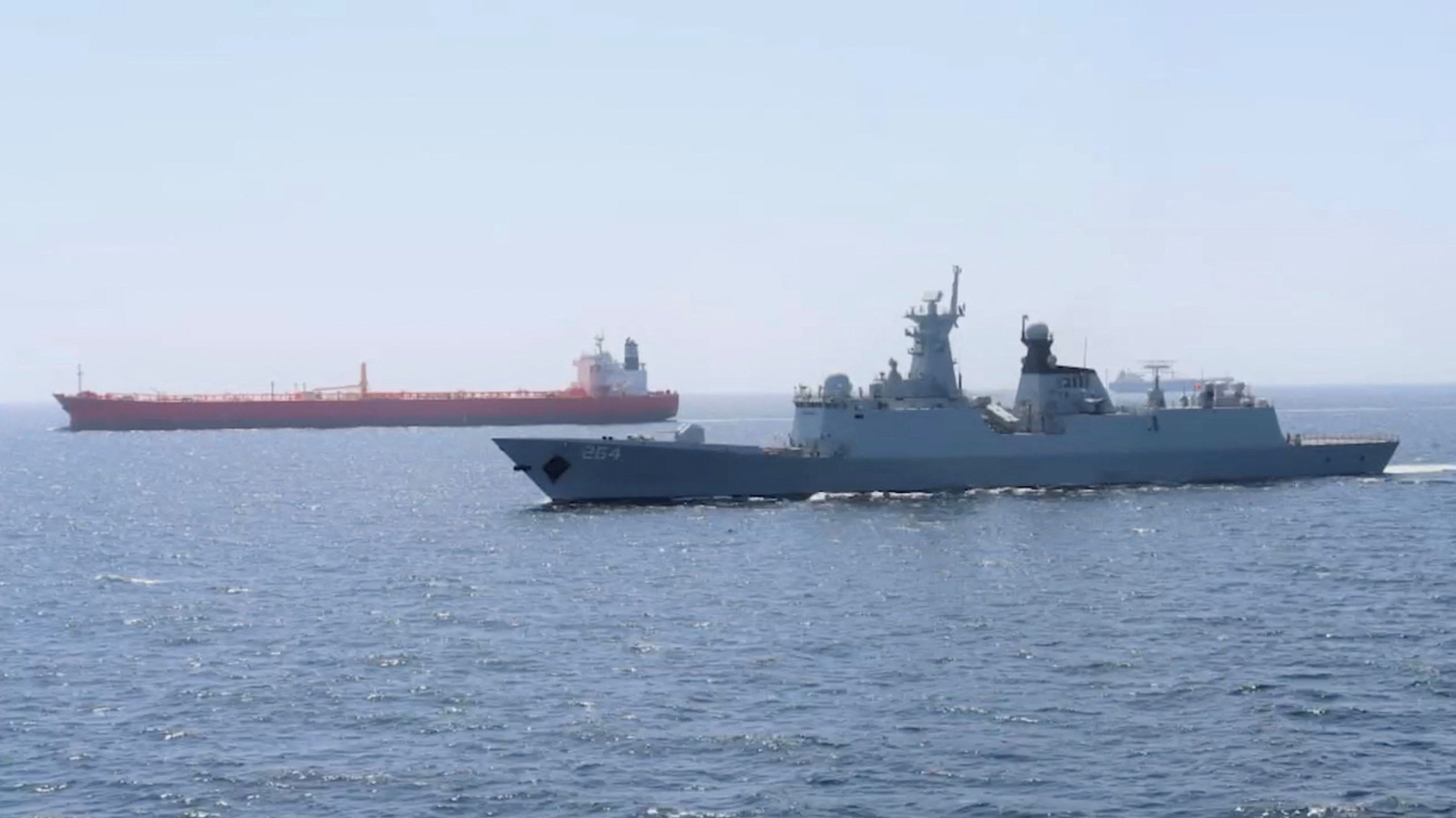 A Pakistan Navy ship escorts a Pakistani merchant vessel.