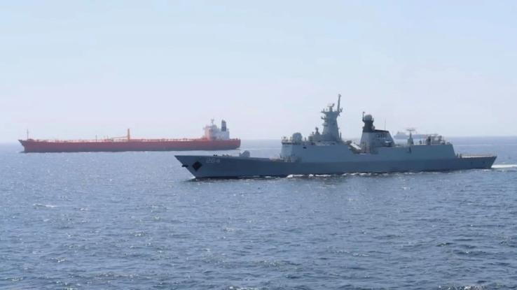 A Pakistan Navy ship escorts a Pakistani merchant vessel.