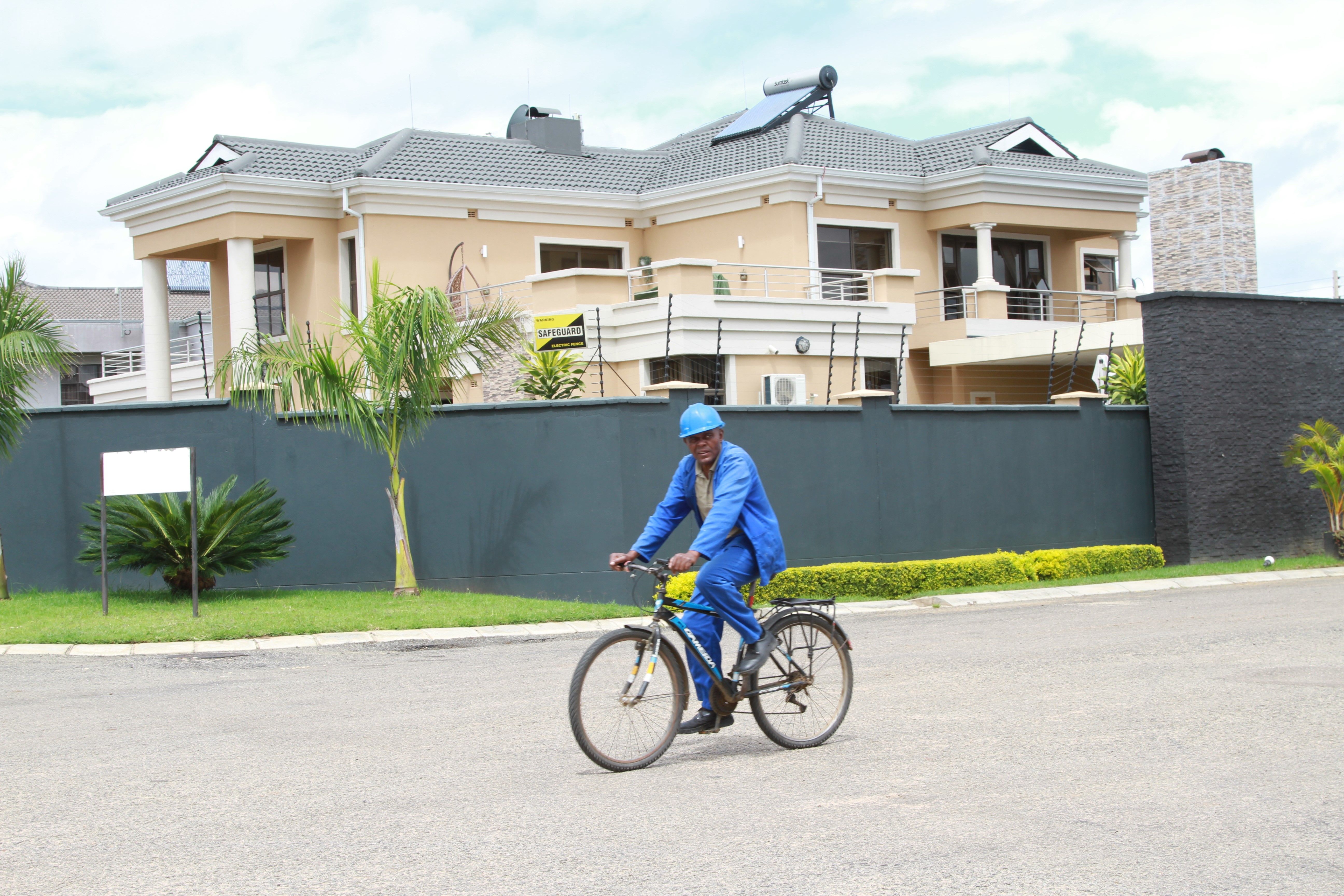 A man cycles past an upmarket housing development in Harare, Zimbabwe.