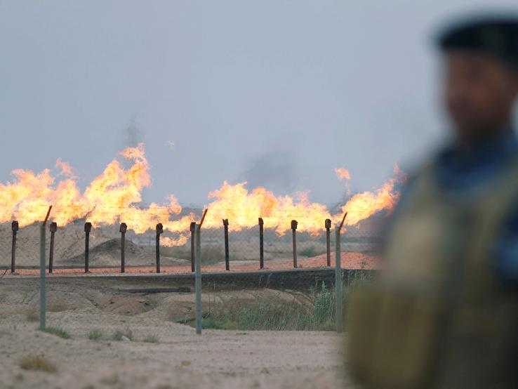 A member of the Iraqi security forces stands guard at an oil burner in al-Zubair oil field, near Basra, Iraq