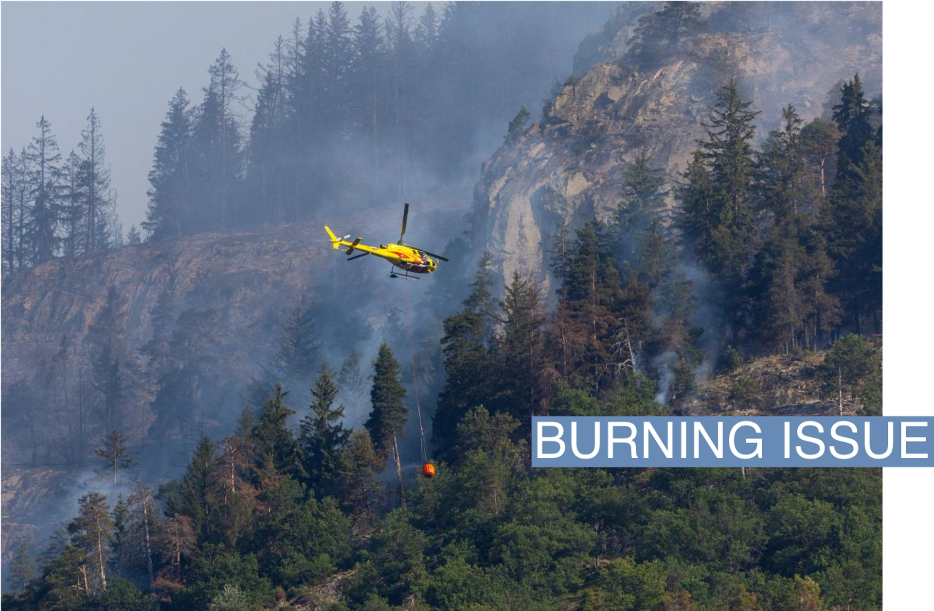 An helicopter carries water to a wildfire on the flank of a mountain in Bitsch near Brig, Switzerland, July 18, 2023. REUTERS/Denis Balibouse