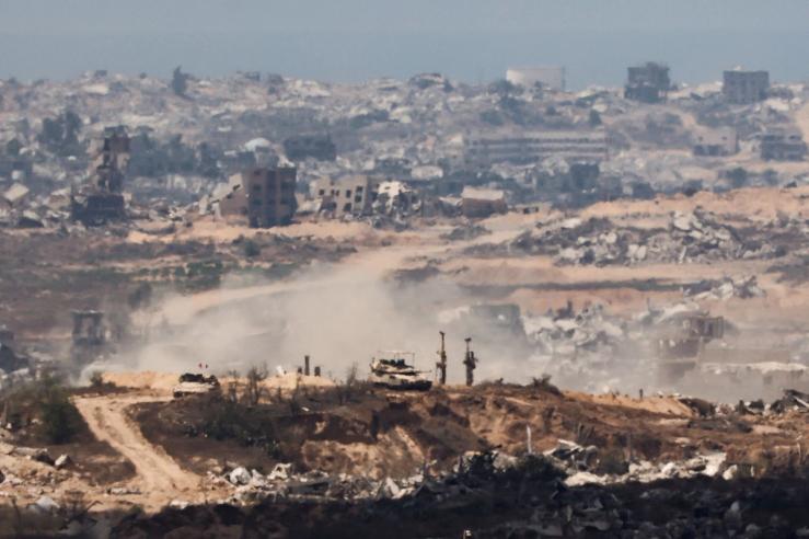 Israeli tank in the foreground of a shot of Gaza.